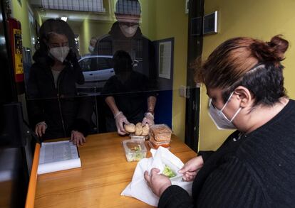 Karen, recogiendo su bolsa de alimentos diaria en el comedor social del barrio.