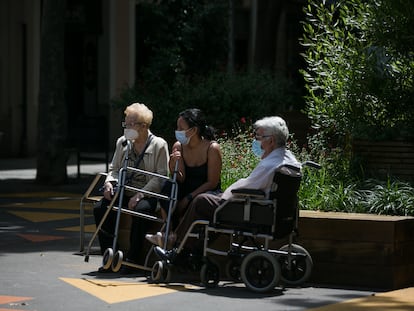 Dos ancianos junto a una joven toman el aire en el barrio de Sant Antoni de Barcelona.