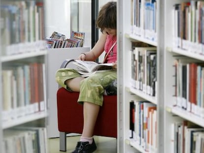 Una mujer lee en la biblioteca Luis Mart&iacute;n Santos, en Vallecas.