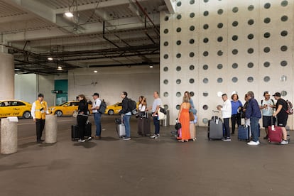 Passengers line up to hail an official Mexico City airport taxi.