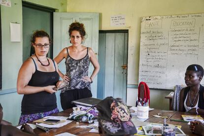 Cristina Sanz e Irene Ariza, voluntarias de Zerca y Lejos, explican cómo utilizar un preservativo ayudándose de un pene de madera.