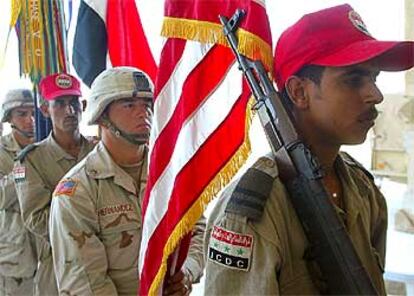 Soldados estadounidenses y miembros de la Defensa Civil iraquí participan en una ceremonia, ayer en Tikrit.