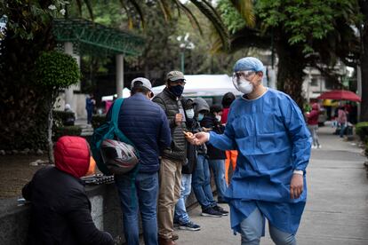 Un doctor cuenta a las personas de la fila para pedir incapacidad por covid-19 a las afueras de la clínica número 28 del IMSS.