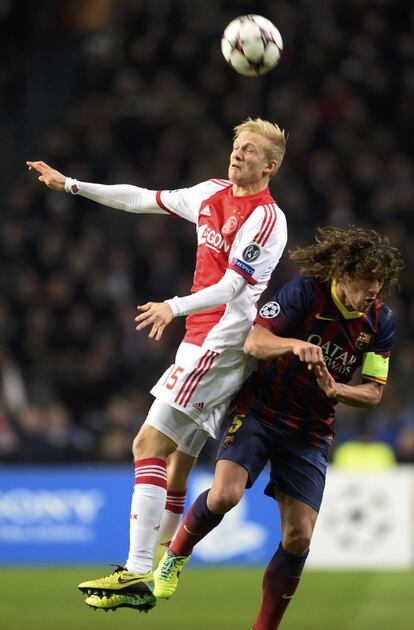 Boilesen salta por el balón con Puyol.