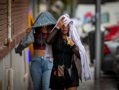 Dos mujeres se protegen de la lluvia en el distrito de Usera, en el sur de Madrid.