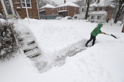 Una mujer quita la nieve de entrada a su vivienda en Parkville, en el estado de Maryland.