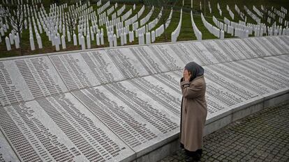Uma mulher reza diante da placa com os nomes das vítimas de Srebrenica em Potocari (Bósnia), em 2016.