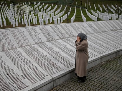 Uma mulher reza diante da placa com os nomes das vítimas de Srebrenica em Potocari (Bósnia), em 2016.