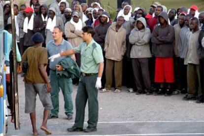 Un guardia civil recibe a un grupo de inmigrantes llegados a la isla canaria de La Gomera.