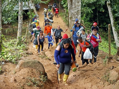 Migrantes venezolanos suben una montaña en el Darién.