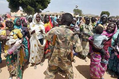 Un policía sudanés trata de mantener a raya a un grupo de mujeres durante un reparto de alimentos en un campo de desplazados de Darfur.