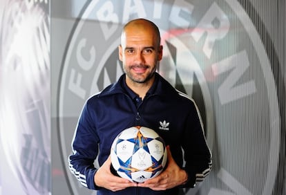 Guardiola posa ante un escudo del Bayern.