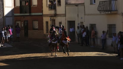 Dos jinetes se abrazan durante una de las carreras previas al descabezamiento de los gansos.