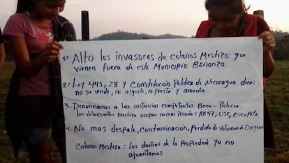 Mujeres wilu muestran un cartel con exigencias luego del ataque señalando que los invasores llegaron desde Bonanza, municipio aledaño.