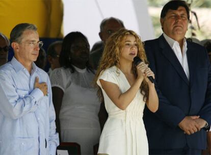 La cantante Shakira, con Álvaro Uribe (izda) y Alan García (dcha), canta el himno nacional colombiano en la ciudad de Leticia