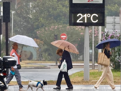 Varias personas se protegen de la lluvia el martes en San Sebastián, donde las máximas apenas llegaron a 21 grados.