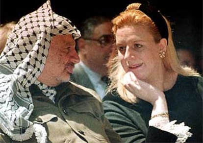 Suha Arafat habla con su esposo, Yasir Arafat, durante un acto público en Gaza en 1995.