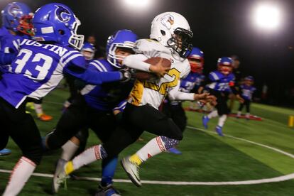 Un niño chino, de nueve años y del equipo de los Eagles, corre para marcar contra los Sharklets en un partido de la Future League American Football en Pekín.