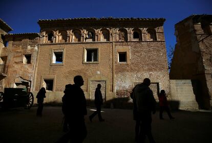 Un grupo de turistas pasan por las ruinas de un edificio, en Belchite viejo.