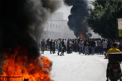 Palestinian protesters near black smoke billowing during clashes with Israeli forces in the West Bank city of Nablus on Friday.
