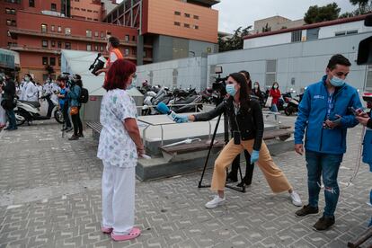 Una periodista de televisión entrevista a profesionales sanitarios frente al Hospital Vall d'Hebron el pasado 12 de mayo.