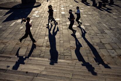 Varias personas pasean y practican deporte en la playa de Somorrostro, en Barcelona. 