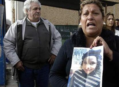 Un vecina de Huelva muestra una foto de Mariluz, la niña de cinco años de etnia gitana que desapareció ayer domingo en la capital onubense.