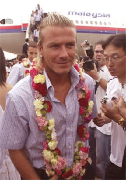 El jugador del Real Madrid, David Beckham, apodado <i>Becks</i> por los aficionados, es agasajado con una corona de flores durante la llegada del equipo blanco a la ciudad china de Kunming, punto de arranque de la gira asiática madridista.