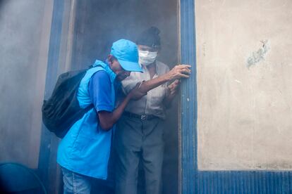 Un anciano recibe ayuda para salir de su casa mientras es fumigada en San Salvador, El Salvador, el 26 de enero de 2016.