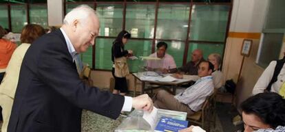 El ministro de Asuntos Exteriores, Miguel &Aacute;ngel Moratinos, introduce su papeleta en la mesa correspondiente del Colegio Santa María de la Hispanidad de la Alameda de Osuna de Madrid.