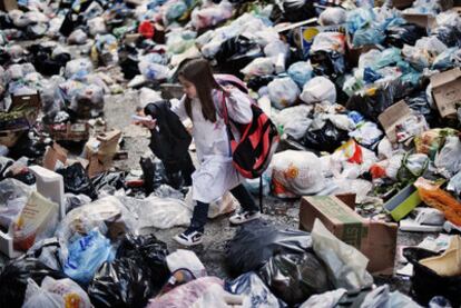 Una niña camina sobre una montaña de basura en Nápoles generada tras una huelga de basureros.