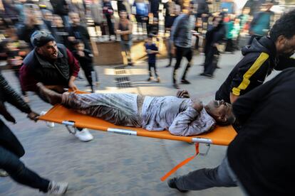 Cuatro personas trasladan en una camilla a un palestino herido en un bombardeo israelí al hospital Nasser, en Jan Yunis, este lunes. 