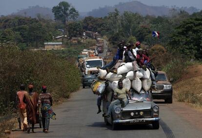 Un vehículo cargado de personas precede a un convoy de más de 100 camiones que llegan a la capital de la República Centroafricana, Bangui.