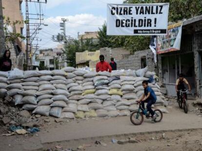 Crianças passam por uma das barricadas erguidas na localidade de Cizre por jovens curdos simpatizantes do PKK.