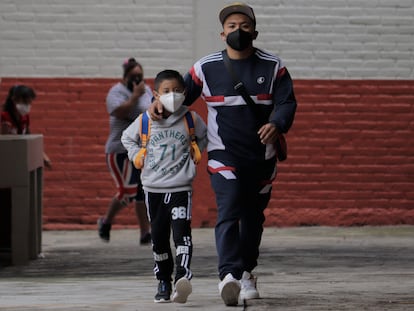 Un padre acompaña a su hijo a una escuela en Ciudad de México, en noviembre de 2021.