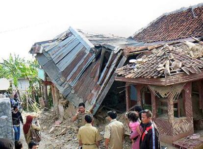 Varias personas miran una casa dañada por el terremoto en la ciudad de Sukabumi, al oeste de la isla de Java