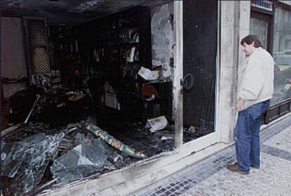 Un transeúnte observa los destrozos en una agencia de viajes en San Sebastián.
