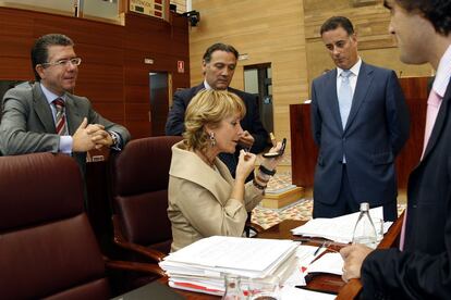 La presidenta de la CAM, la popular Esperanza Aguirre (sentada), retocándose el maquillaje, rodeada de varios de sus colaboradores, durante la segunda jornada del debate del estado de la región, en la Asamblea de Madrid. En la foto, desde la izquierda: Francisco Granados, Alfredo Prada, Alberto López Viejo y Juan José Güemes, observando a su jefa de filas. En una imagen de 20 de octubre de 2006.