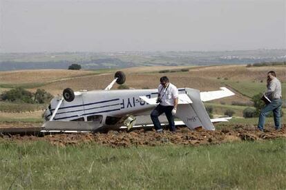 Agentes de la Guardia Civil fotografían la avioneta Cessna 172 en la que viajaban los dos hombres heridos en el accidente.