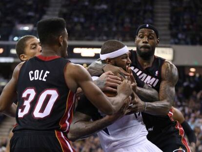 LeBron James (derecha) y Cole impiden el paso a DeMarcus Cousins.