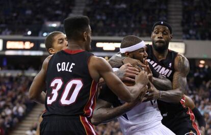 LeBron James (derecha) y Cole impiden el paso a DeMarcus Cousins.