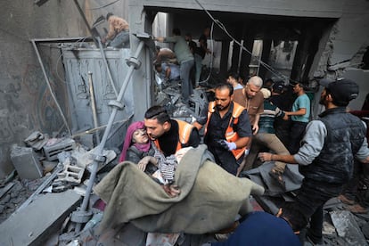 Una mujer es rescatada de entre los escombros de un edificio bombardeado por Israel en Jan Yunis, este sábado. 
