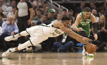 Antetokounmpo y Tatum se lanzan a por un balón.