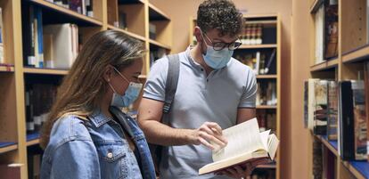 Dos estudiantes en una biblioteca.