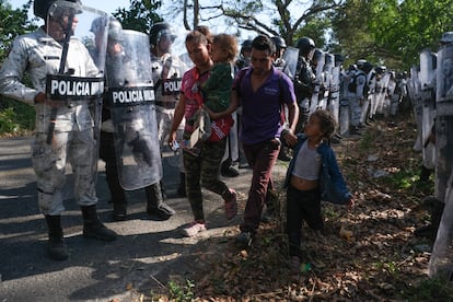 Una familia hondureña es retenida por la Guardia Nacional en uno de los controles carreteros instalado en Chiapas. 