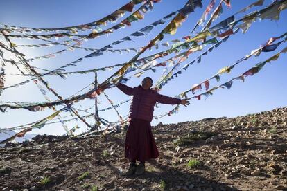 Un monje budista indio juega con el viento entre banderas de oración en una colina que domina el monasterio Tnagyud Gompa. El monasterio está ocupado actualmente por alrededor de 20 monjes, que reciben un goteo de visitantes intrépidos.