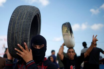 El Ejército israelí argumenta que sus tropas están defendiendo la frontera y disparando conforme con las normas de enfrentamiento. En la fotografía, manifestantes palestinos sujetan neumáticos, en la frontera entre Gaza e Israel, el 14 de mayo de 2018.