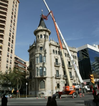 Momento en el que una grúa desmonta el pararrayos de la cúpula del edificio de la Cámara de Comercio de Tarragona.