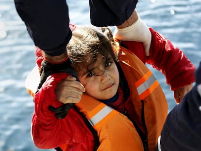 Agentes de la Guardia Costera griega trasladan a una niña a un buque durante la operación de rescate en mar abierto, cerca de la isla griega de Lesbos.