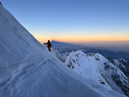 Benjamin Védrines, al amanecer en la ruta Schell del Nanga Parbat, cuya sombra se proyecta a sus espaldas.